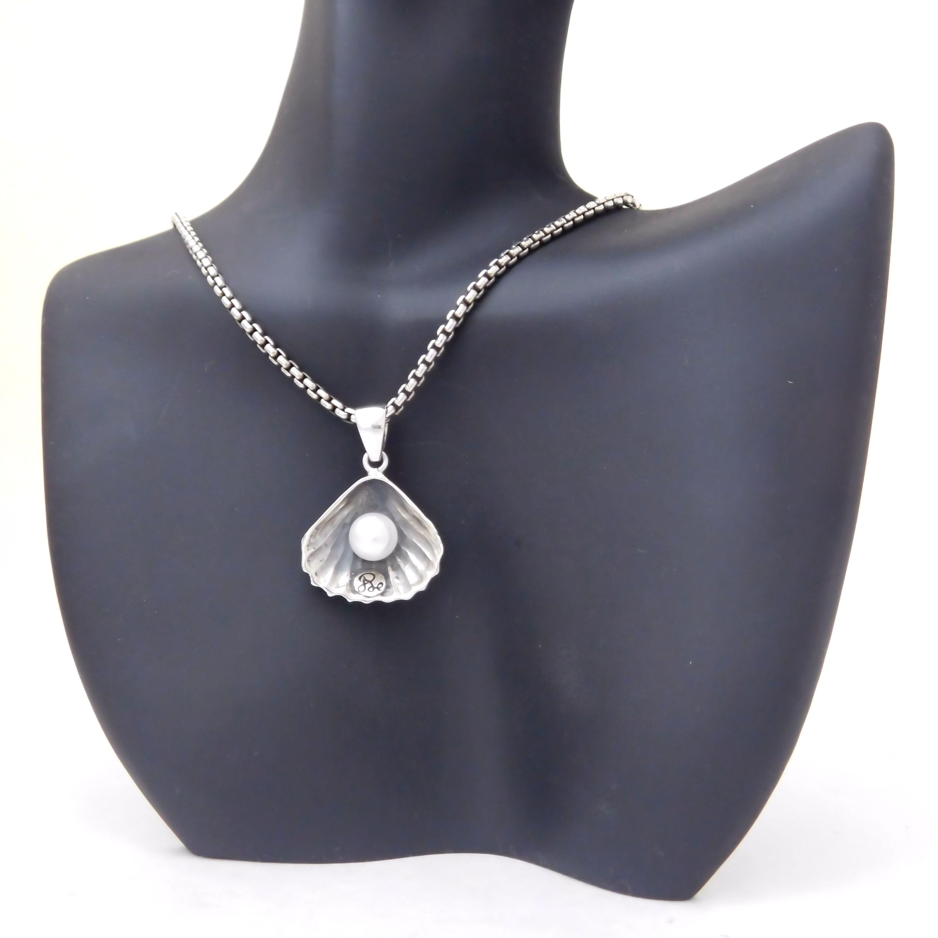 Sterling silver shell with pearl inside pendant on necklace.                                                                                                                                                                                              