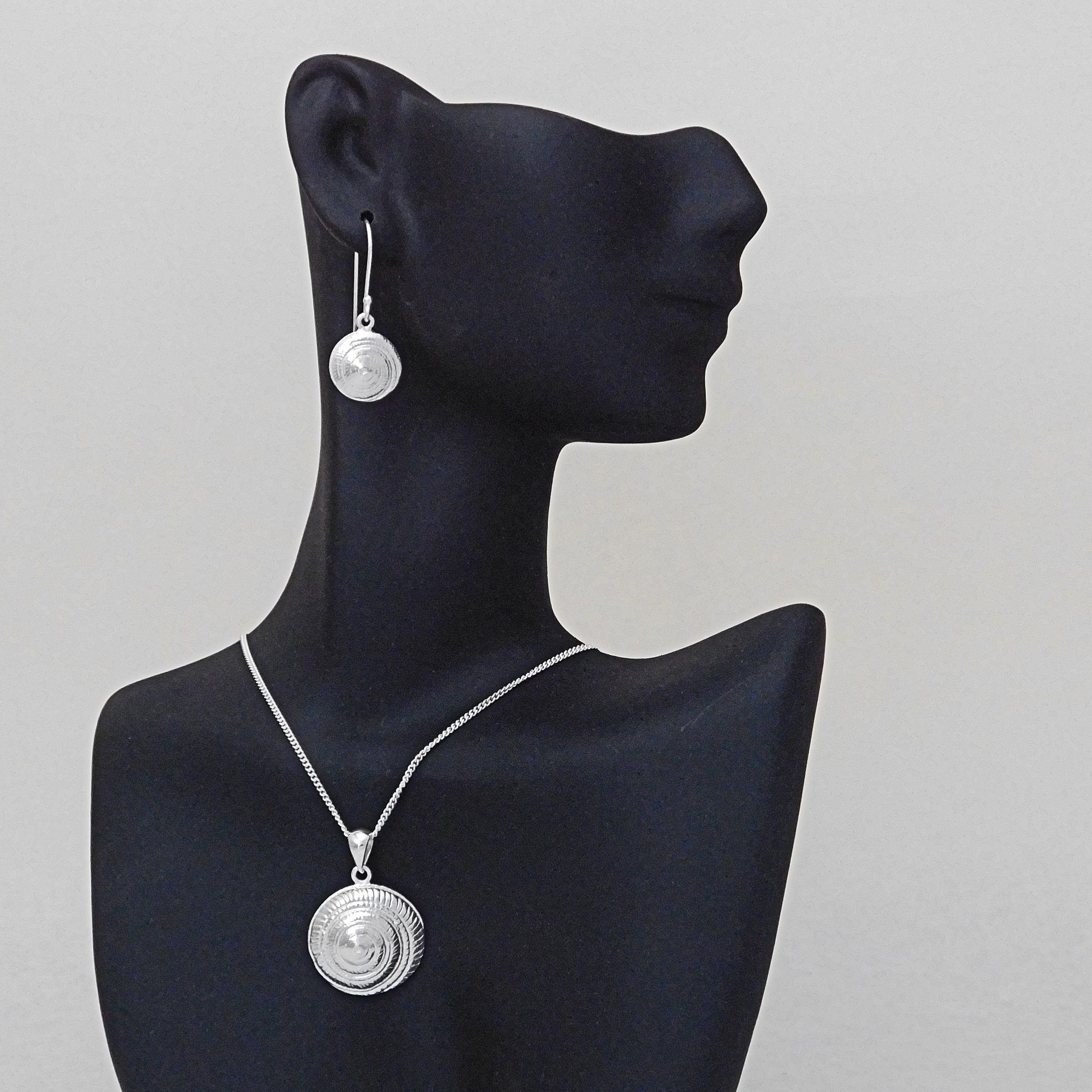 Silver round disc shell jewelry necklace and earrings with hypnosis spiral circles.                                                                                                                                                                       