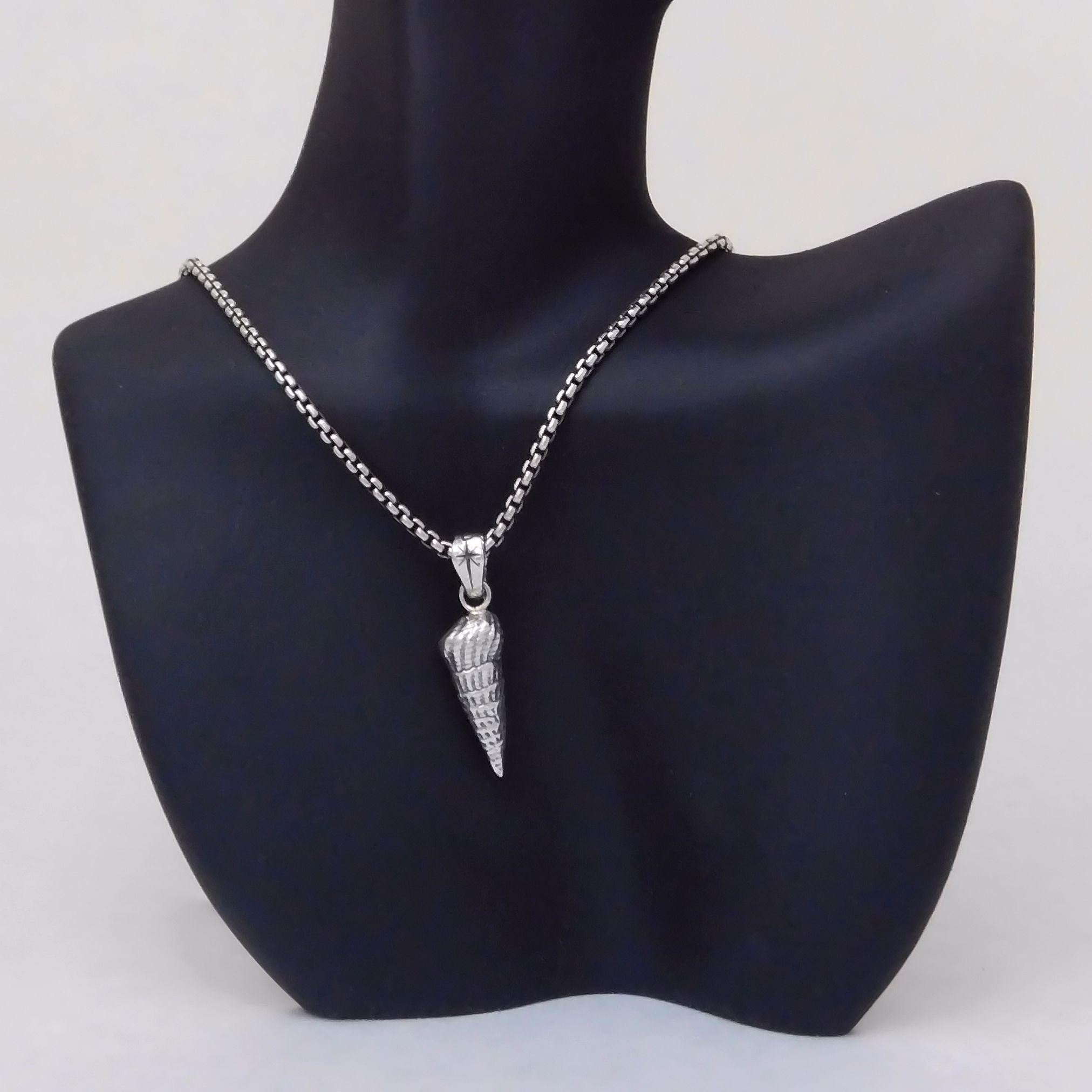 Sterling silver auger shell pendant on necklace.                                                                                                                                                                                                          