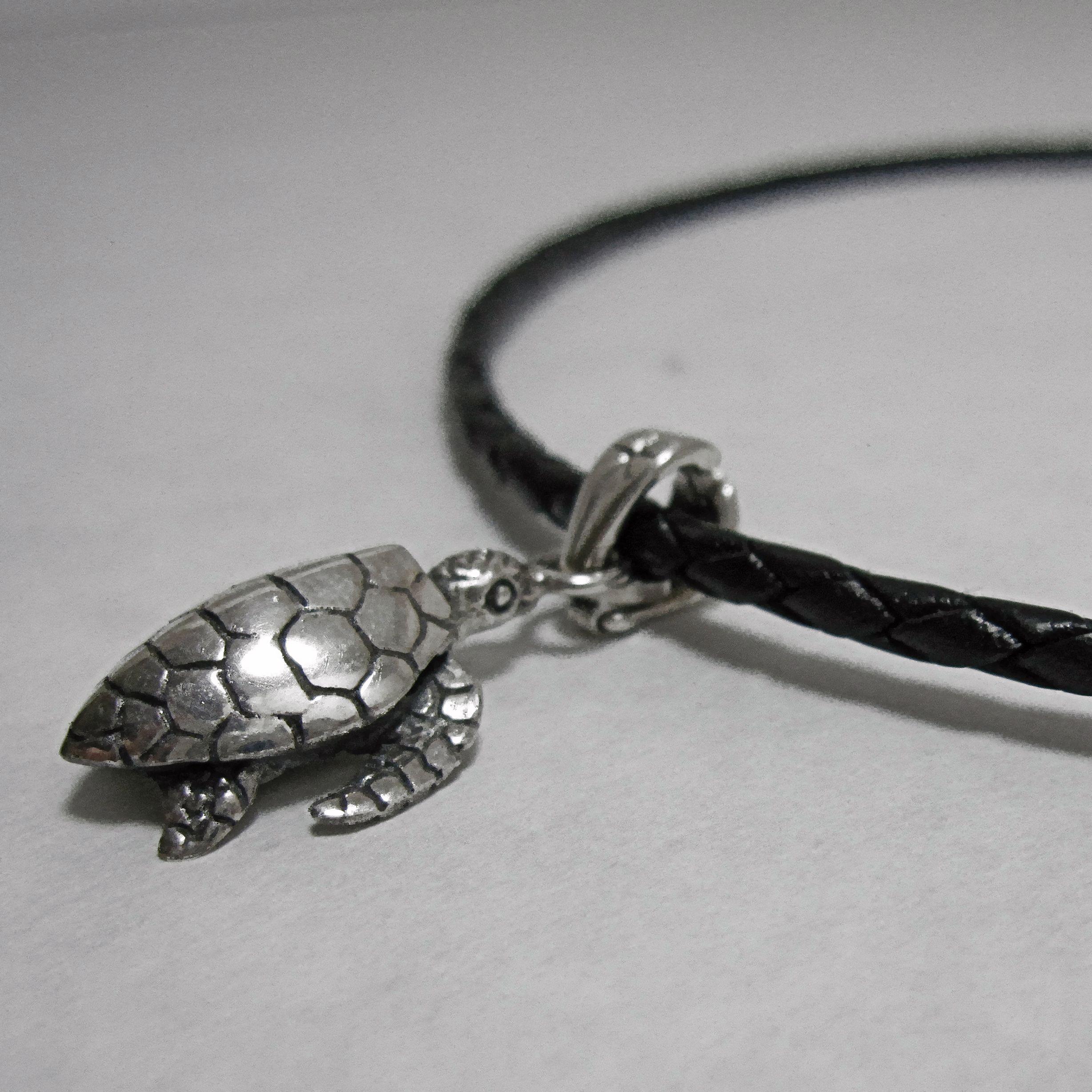 Silver turtle pendant on leather cord.                                                                                                                                                                                                                    