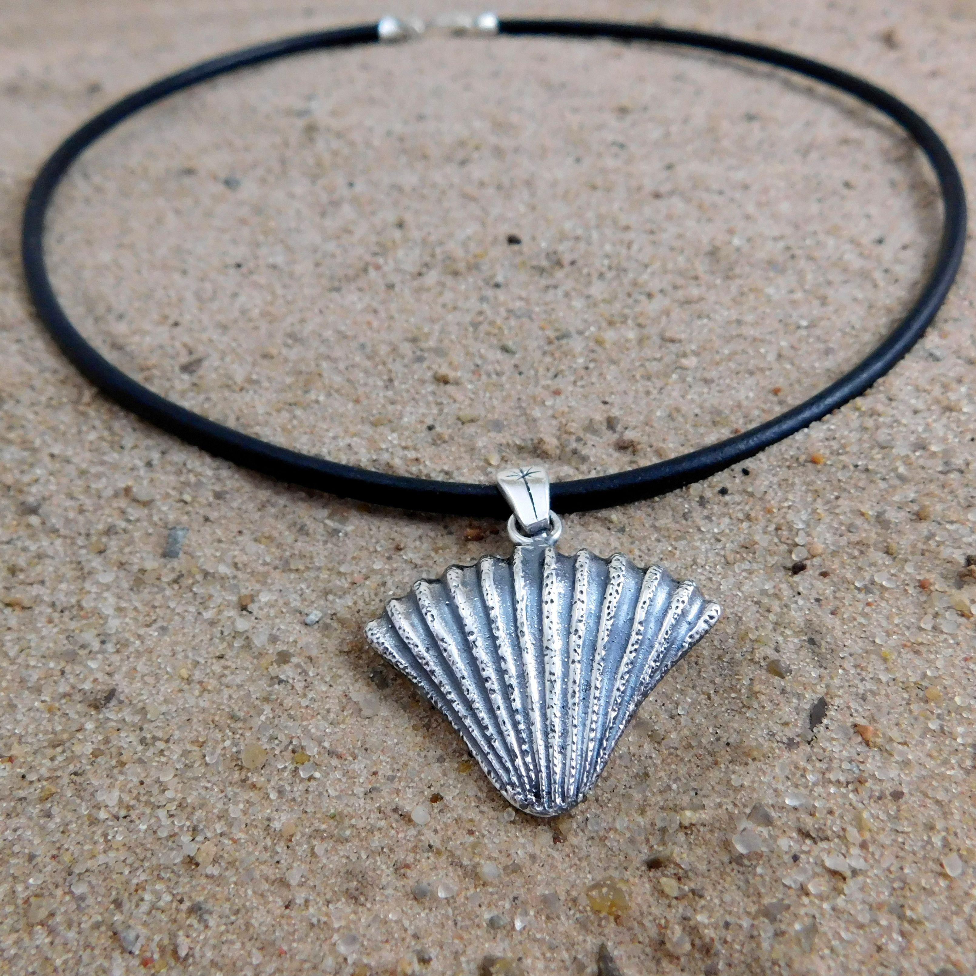 Silver shell on black leather choker necklace.                                                                                                                                                                                                            